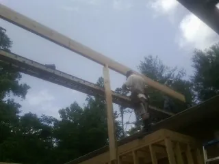 Carpenter setting a ridge beam over a new addition frame — Ice Dam Removal by Roofing Brothers in Fond Du Lac