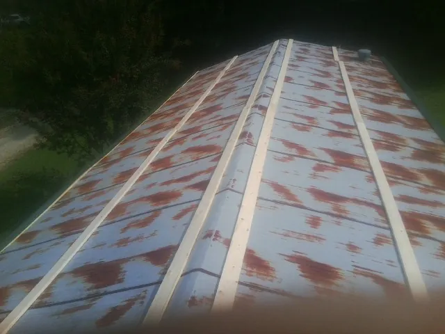 Rusted metal roof panels with new wood purlins before replacement — Storm Damage Roof Repair in Fond Du Lac by Roofing Brothers