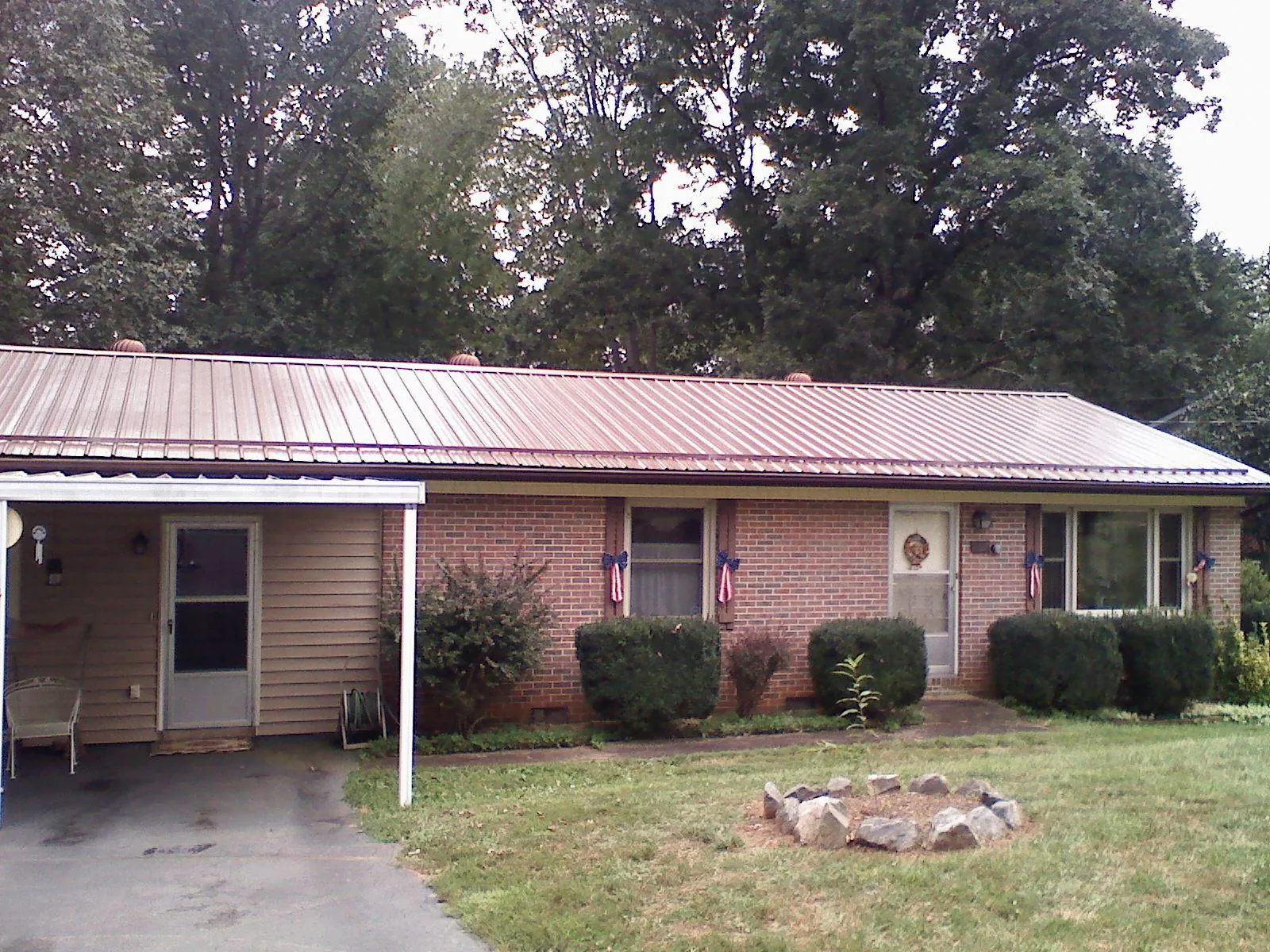Bronze metal roof and carport on a brick ranch home — Roof Repair work by our crew in Fond Du Lac