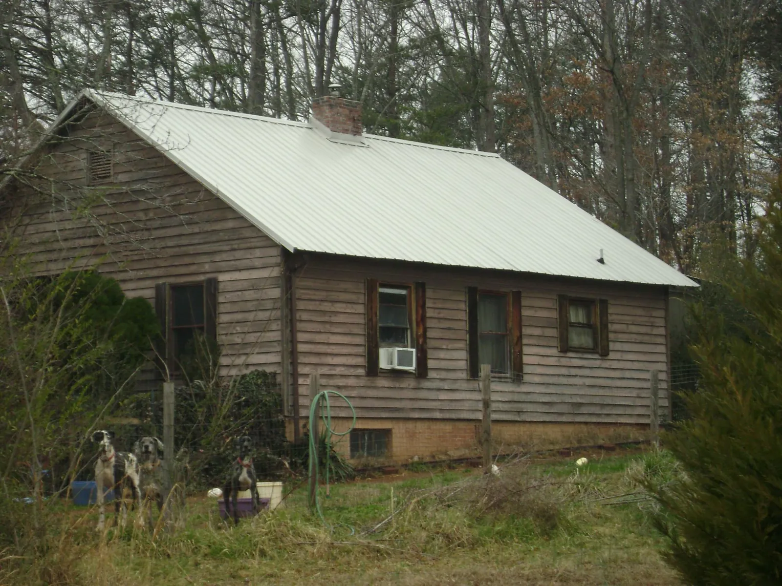 White metal roof on an old wood sided farmhouse, from a Metal Roof Installation job in Fond Du Lac